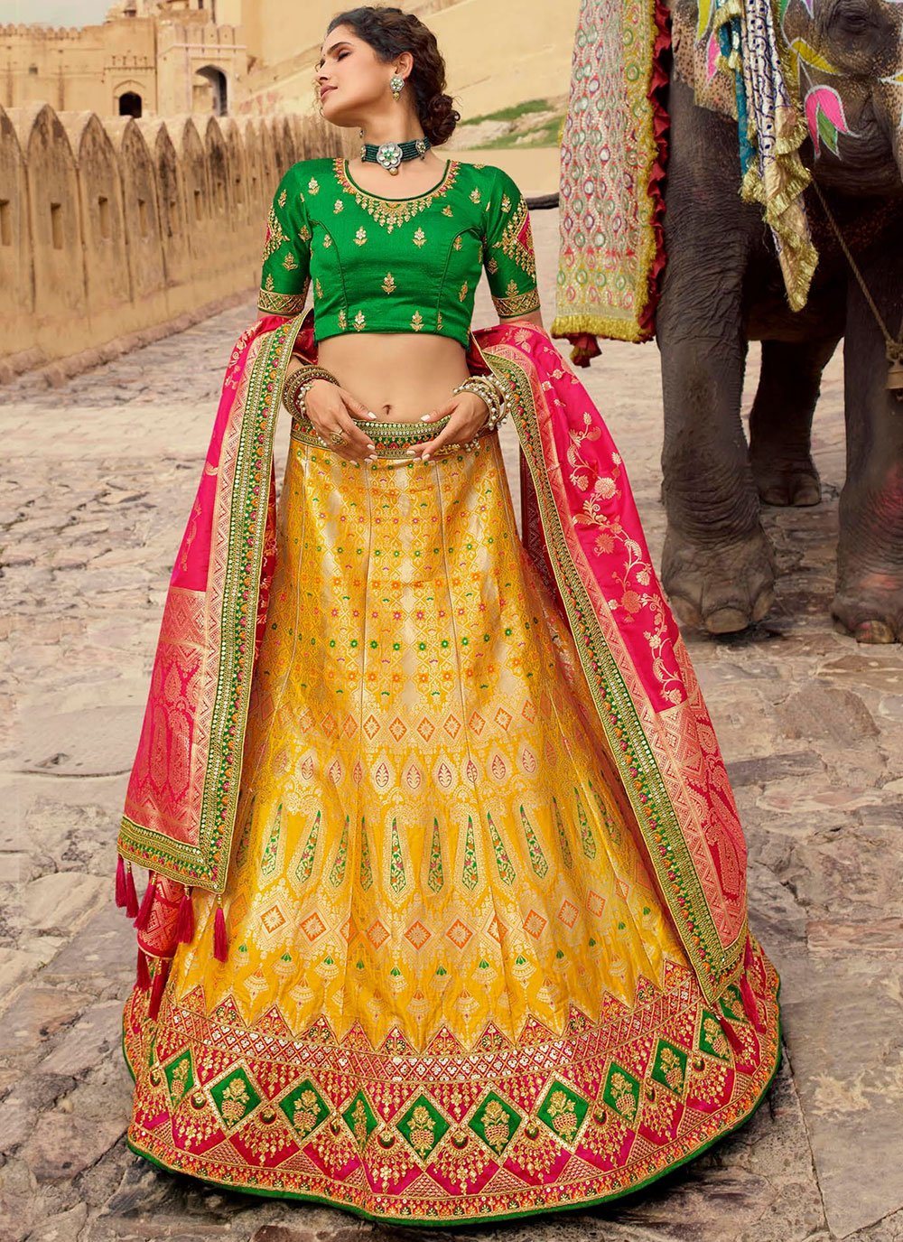 Stunning yellow and pink color combination pattu lehenga and blouse with  net dupatta. Blouse with hand