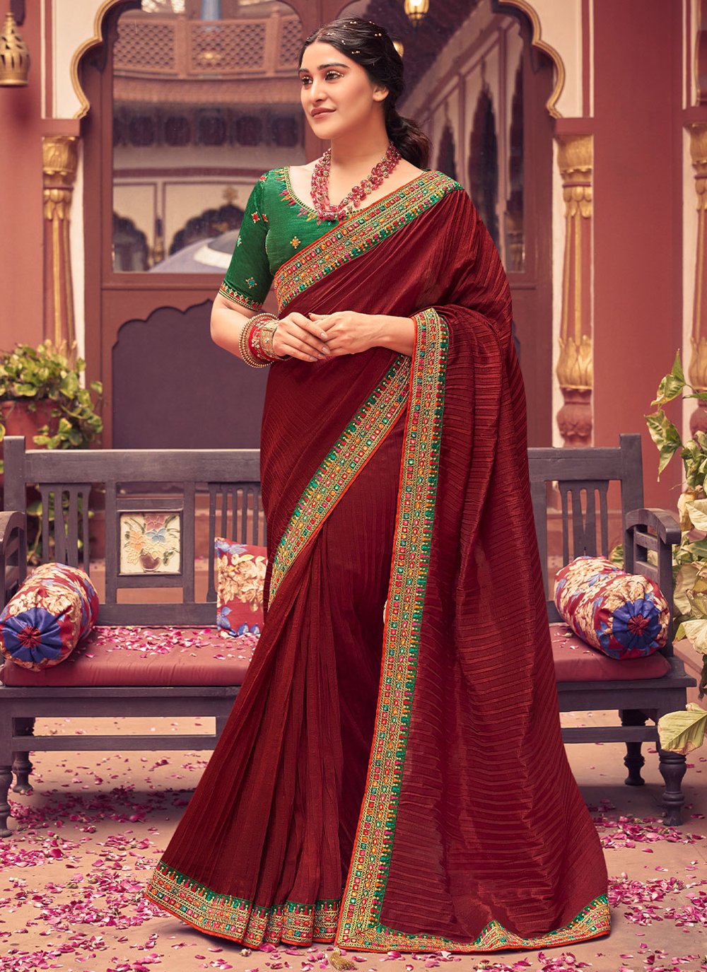 Photo of South Indian bride dressed in a maroon saree with a dark green  blouse.